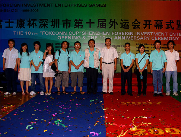 深圳市黑眼睛廣告有限公司參與外運(yùn)會(huì)會(huì)務(wù)工作的部分員工和文總、徐總在開(kāi)幕式背景版前留影